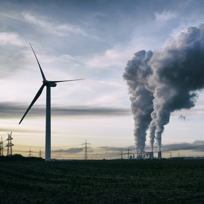 Kraftværk og vindmølle illustrerer forskel mellem sort og grøn energi