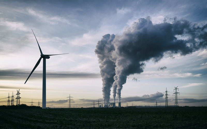 Kraftværk og vindmølle illustrerer forskel mellem sort og grøn energi